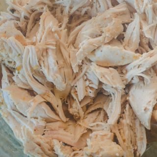 close up of instant pot shredded chicken in glass bowl