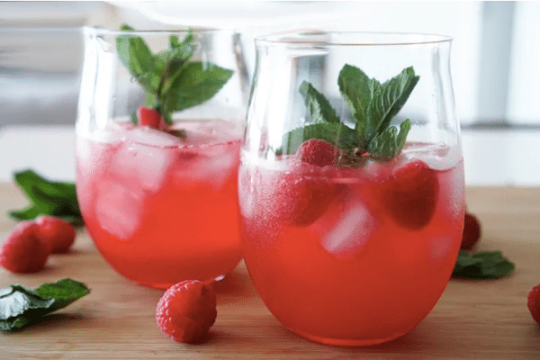 raspberry gin fizz in a glass with garnish