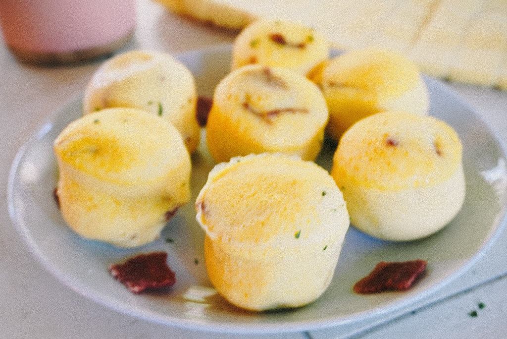 bacon and cheese egg bites on a white plate