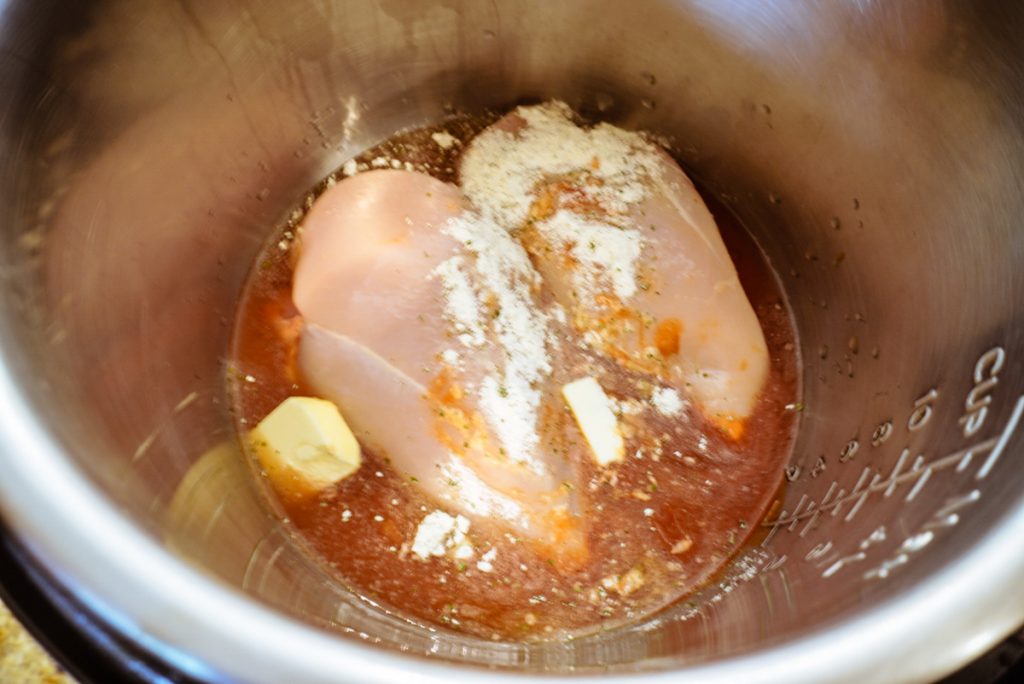 chicken breast with ingredients on top inside instant pot
