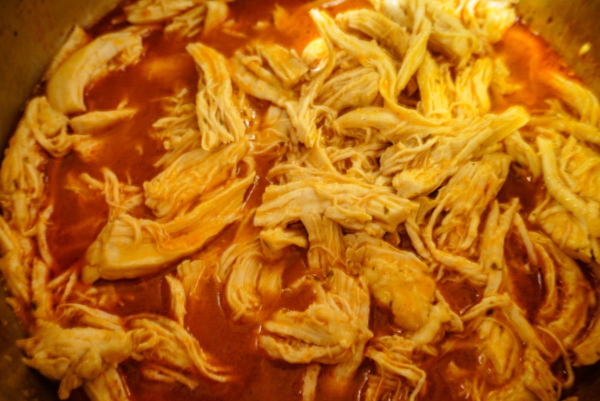 close up of shredded buffalo chicken in an instant pot