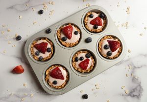granola cups with fruit inside a muffin tin