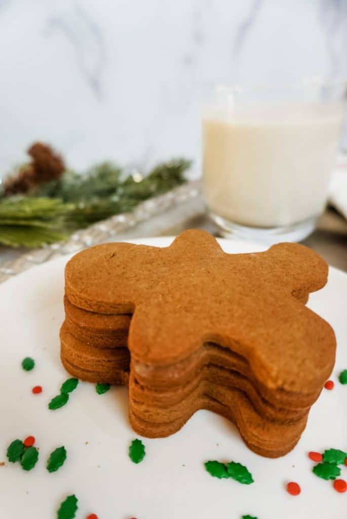 a stack of gingerbread men with milk in the background