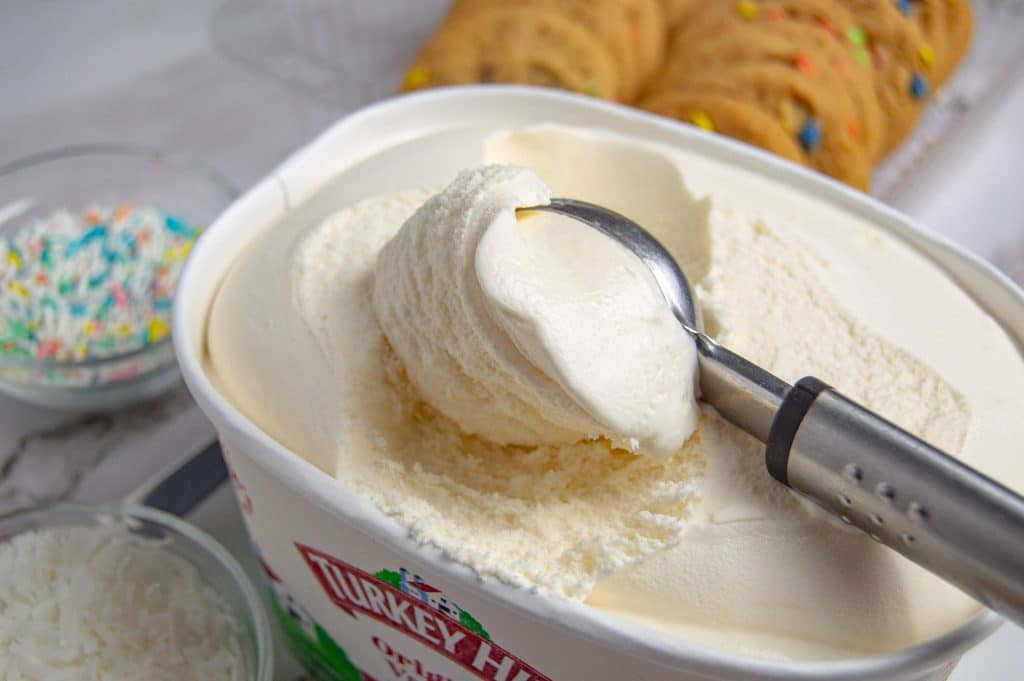 an ice cream scoop scooping vanilla ice cream