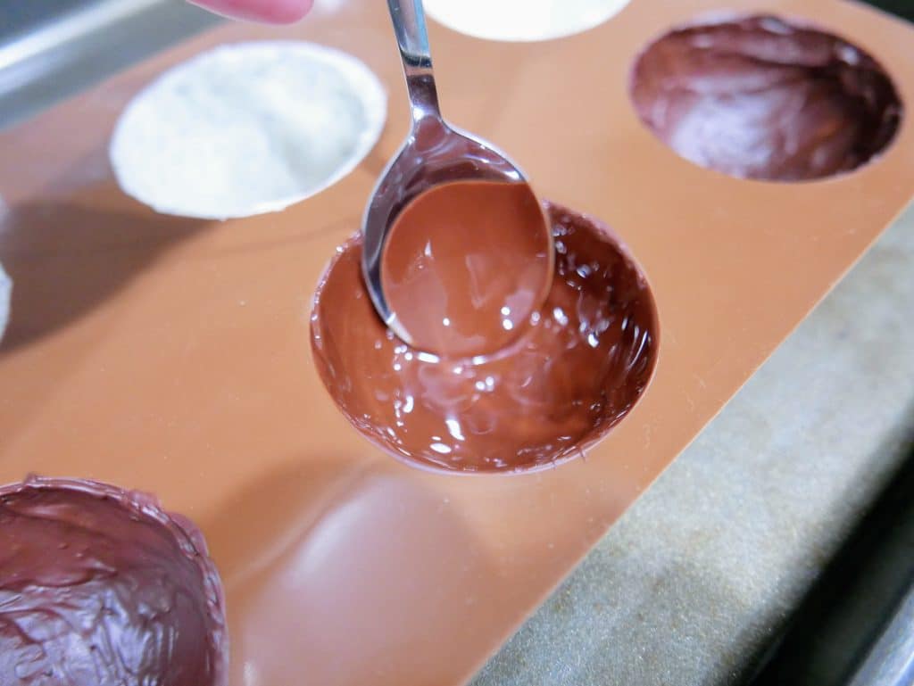 adding melted chocolate to the mold