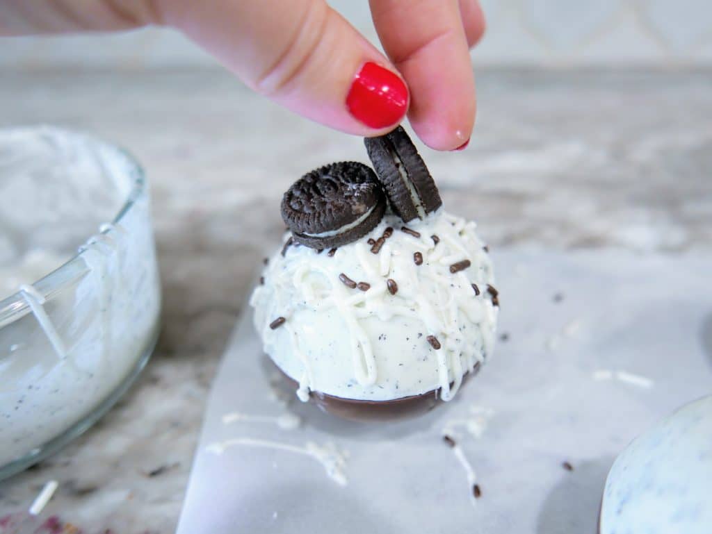topping hot chocolate bomb with 2 mini oreos