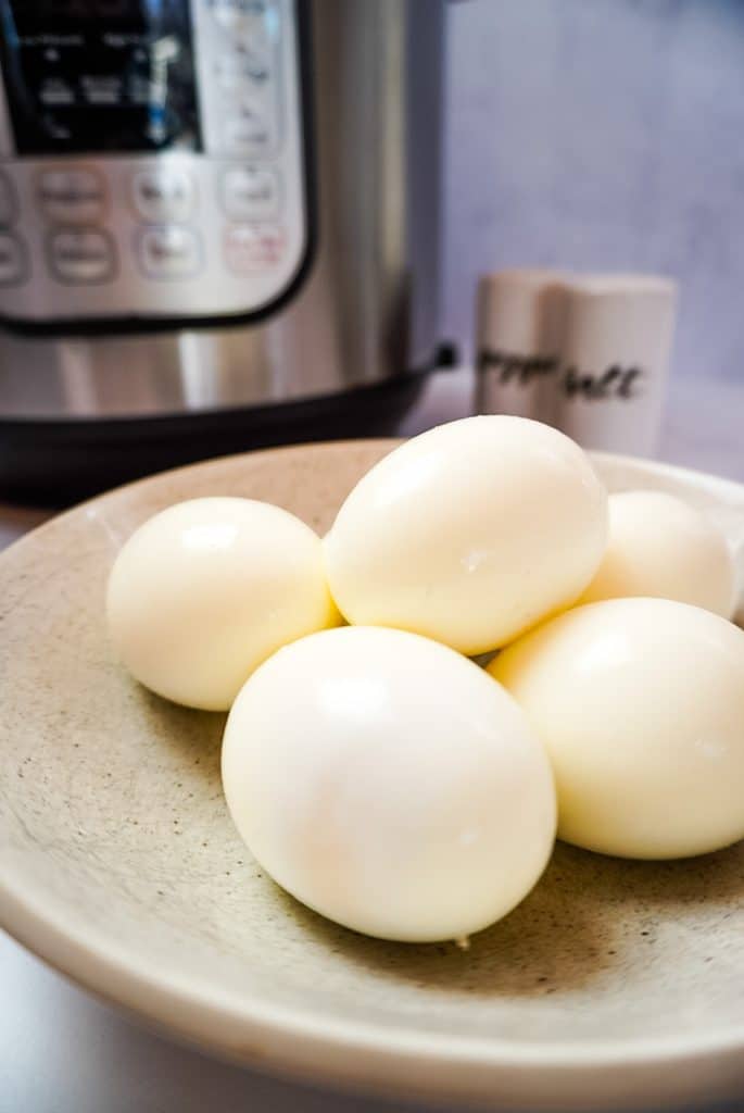 hard boiled eggs on a plate in front of an instant pot