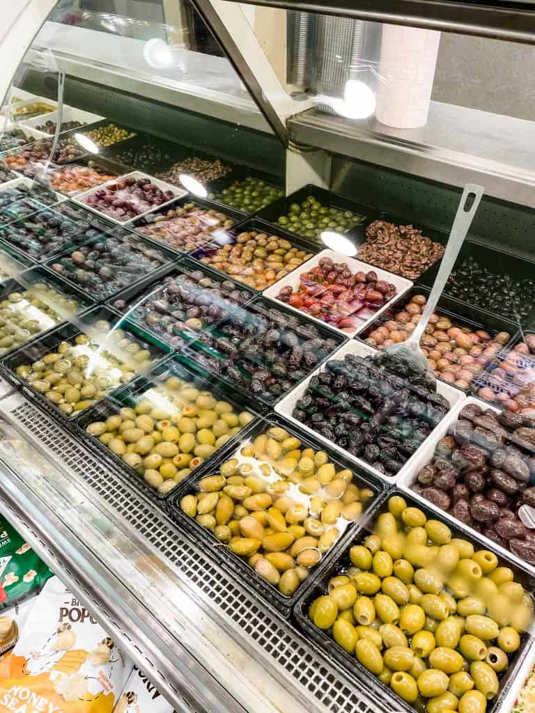 different types of olives in a glass case