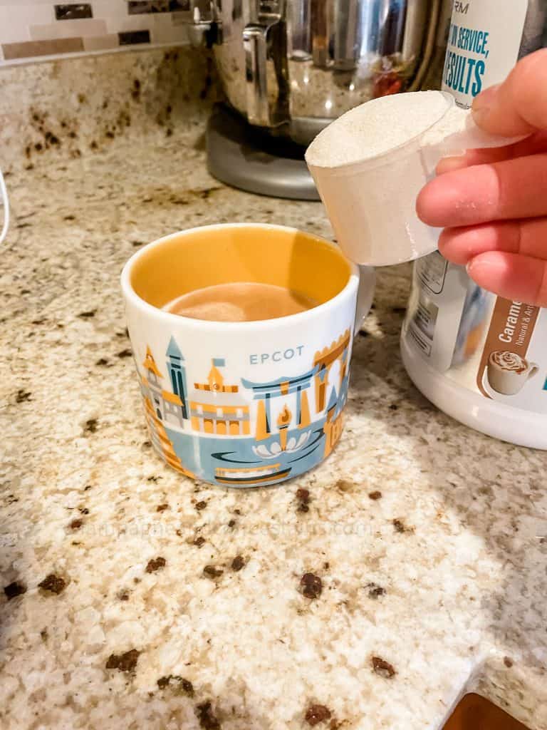 pouring level 1 protein powder into a coffee cup