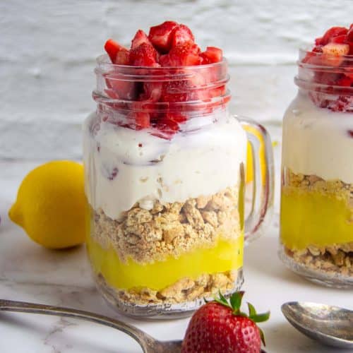 cheesecake in a jar with a strawberry in a spoon
