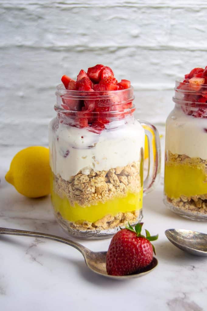 cheesecake in a jar with a strawberry in a spoon