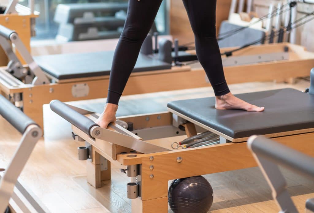 woman stretching legs on reformer