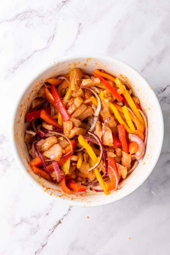 peppers mixed with chicken and seasoning in a bowl