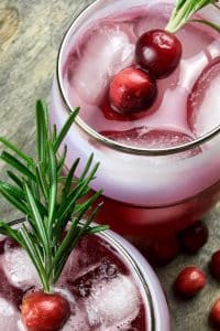 cranberry spritzer with a cherry and rosemary garnish