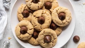 chocolate peanut butter blossoms on a plate with hershey kiss on the side