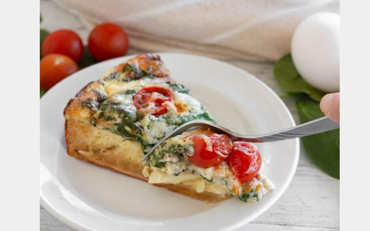 fork cutting into a piece of quiche