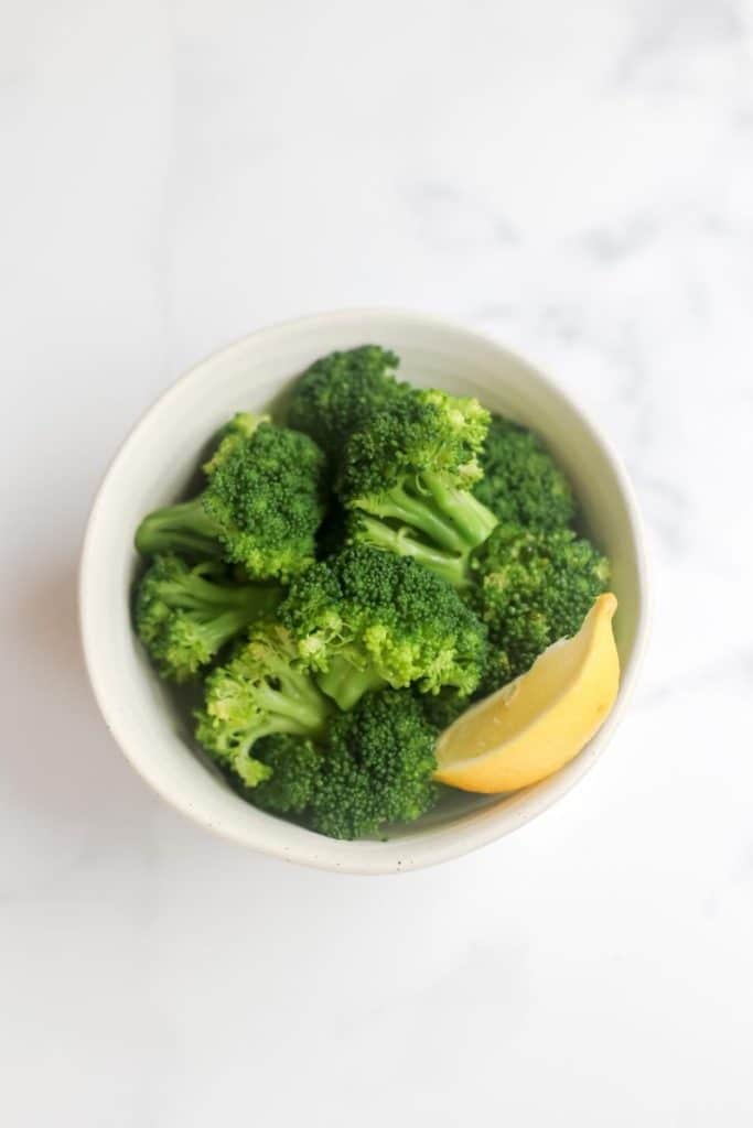 broccoli in a dish with a lemon